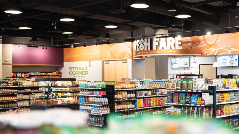 This photo highlights a modern Street Corner Urban Market situated in a high-visibility retail center alongside nationally recognized brands like Starbucks. Th