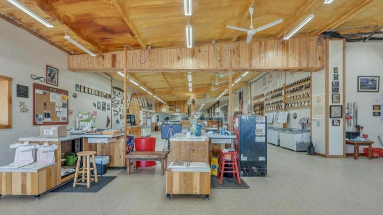Interior storefront features multiple check-out counter locations, wall space for coolers or other displays, and shelving.