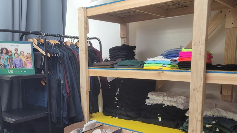 One of our clothing racks and a large shelf where we keep product samples.