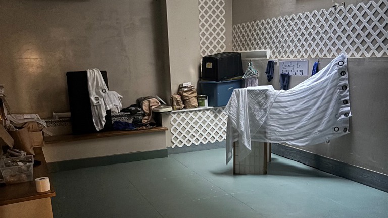 Large back room used for laundry and storage with open space for supplies.
