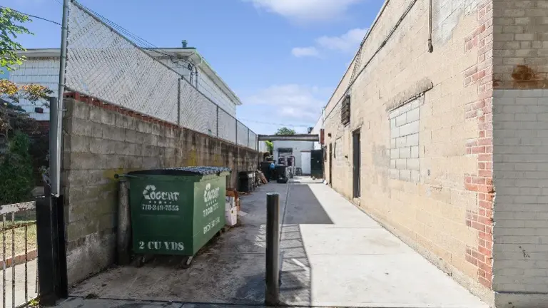 Functional back alley with easy access for deliveries, waste disposal, and vendor drop offs.
