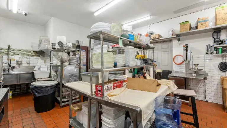 Well organized prep and storage area space with professional equipment and shelving for seamless kitchen workflow