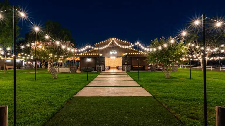 Wedding Barn Exterior at Night The 3,000 sq. ft. ADA-compliant wedding barn illuminated under string lights, ready to host events with seating for 200 guests.