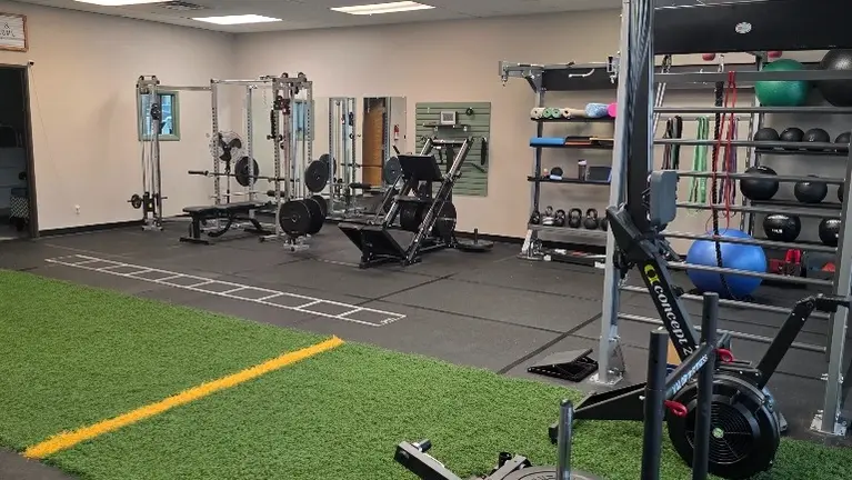 From entrance, looking right. Gym Rax rig, C2 rower, 2-in-1 sled, leg press/hack squat, squat rack w/ lat tower and cable wings