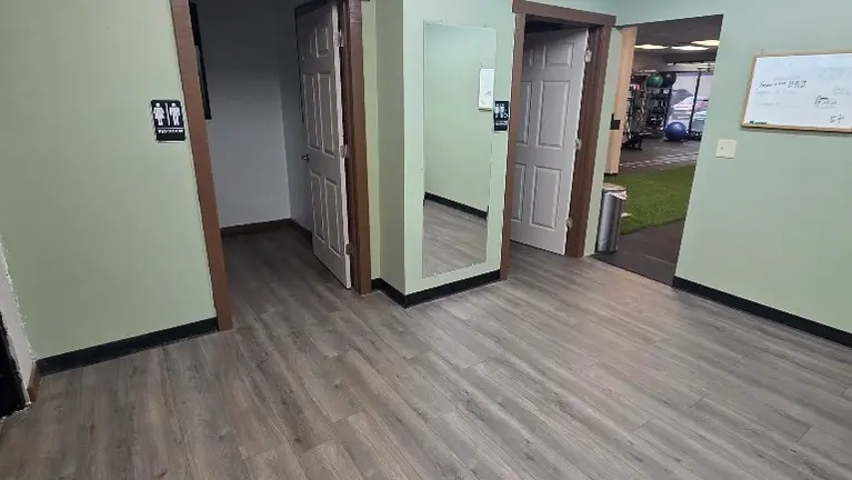 Locker room with ADA and regular restrooms, full length mirror, access to back alley