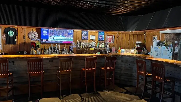 Full-service bar with extensive seating, complete liquor setup, and efficient service layout. Full-service bar with extensive seating, complete liquor setup, and efficient service layout.