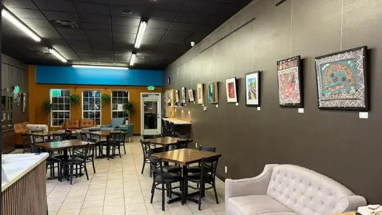 Cozy seating with local art on the walls, a living room up front makes it all  the more inviting.  