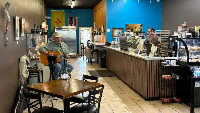 A full espresso bar and pastry kitchen with a display case for service, more seating in the back.  A pickup window offers convenience to on the go customers