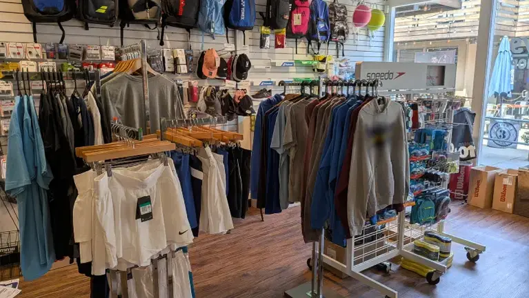 Store branded and other top brand apparel. Swim goggles, caps, and fins are displayed as well.