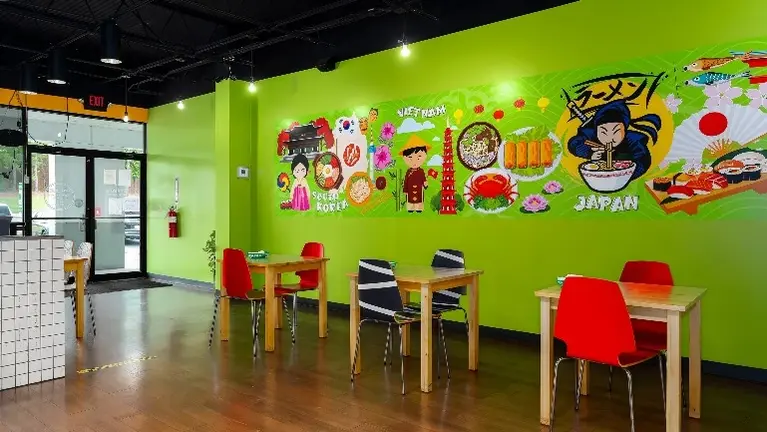 Spacious dining area with service counter, customer seating, and colorful interior finishes. Spacious dining area with service counter, customer seating, and colorful interior finishes.