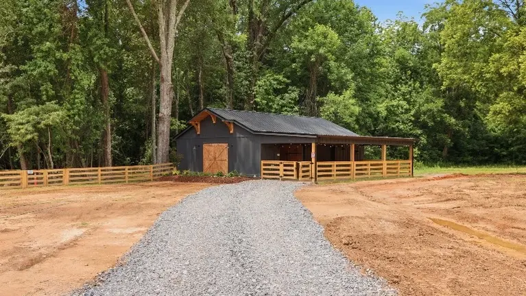 The custom barn offers a versatile space for farm experiences and gatherings, complete with a maintenance shop and stables built right in. The custom barn offers a versatile space for farm experiences and gatherings, complete with a maintenance shop and stables built right in.