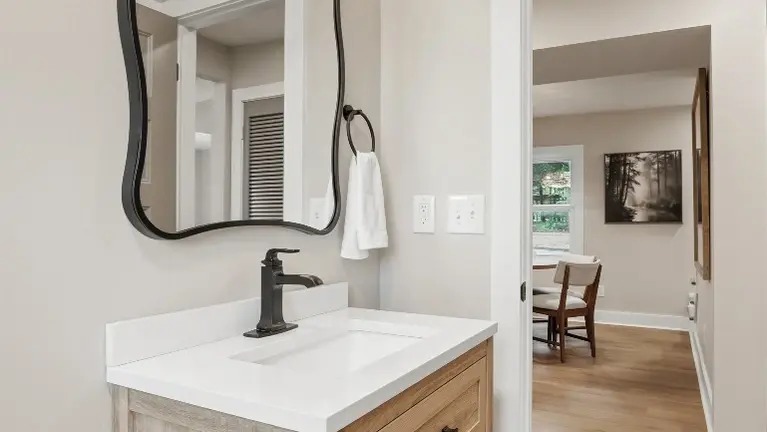 A wood vanity and black fixtures give this bathroom a clean, modern feel, just off the main living area. A wood vanity and black fixtures give this bathroom a clean, modern feel, just off the main living area.