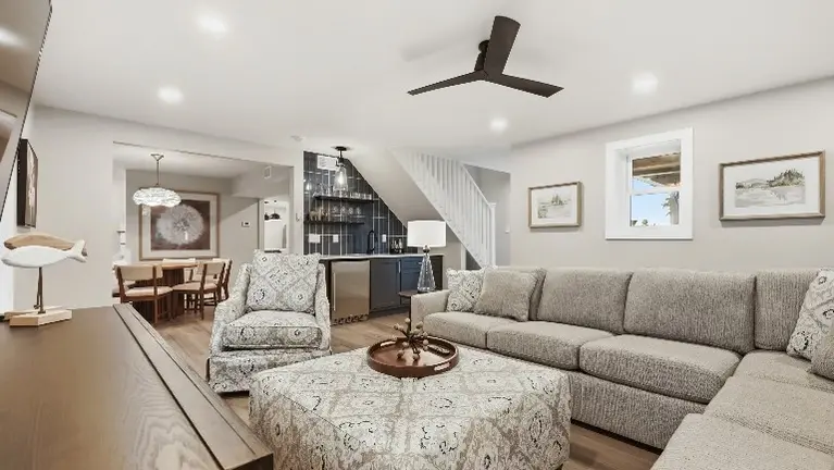 A cozy sitting area with a sectional sofa and armchairs opens into the dining space beyond, giving guests a comfortable spot to relax together. A cozy sitting area with a sectional sofa and armchairs opens into the dining space beyond, giving guests a comfortable spot to relax together.