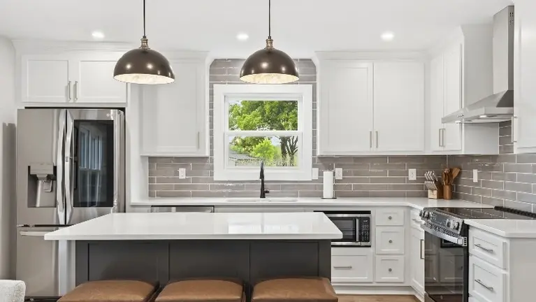 The kitchen features stainless steel appliances, a large center island with seating, and pendant lighting, giving guests plenty of room to cook and gather toge The kitchen features stainless steel appliances, a large center island with seating, and pendant lighting, giving guests plenty of room to cook and gather toge