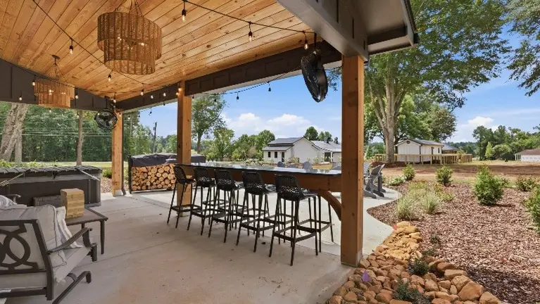 An outdoor bar sits ready for guests to gather, pour a drink, and settle in for the evening. An outdoor bar sits ready for guests to gather, pour a drink, and settle in for the evening.