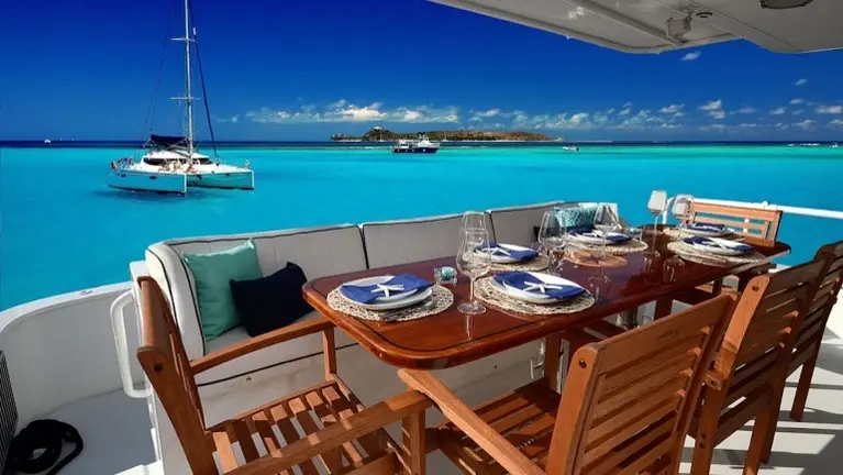 Al fresco dining for eight with breathtaking Caribbean views—the perfect setting for every breakfast, lunch, sunset cocktail, and dinner at anchor. Al fresco dining for eight with breathtaking Caribbean views—the perfect setting for every breakfast, lunch, sunset cocktail, and dinner at anchor.