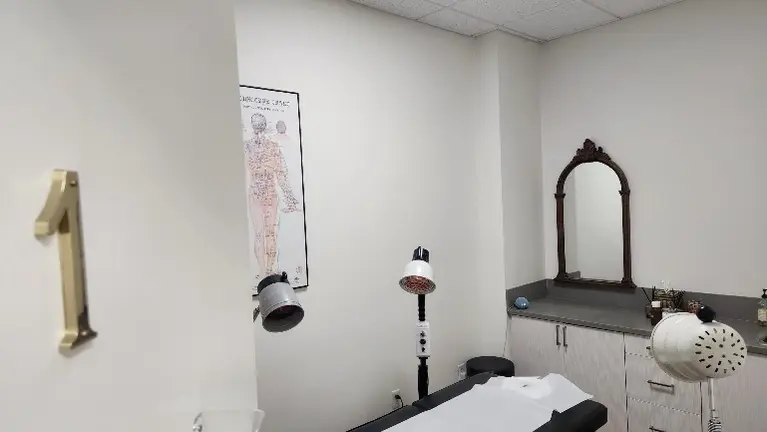 Private treatment room with treatment table, therapy lamps and built-in cabinetry