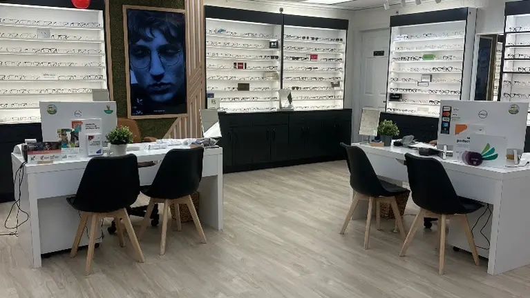 Spacious, modern optical retail space featuring multiple customer service stations, illuminated eyewear displays, and a professional turnkey setup.
